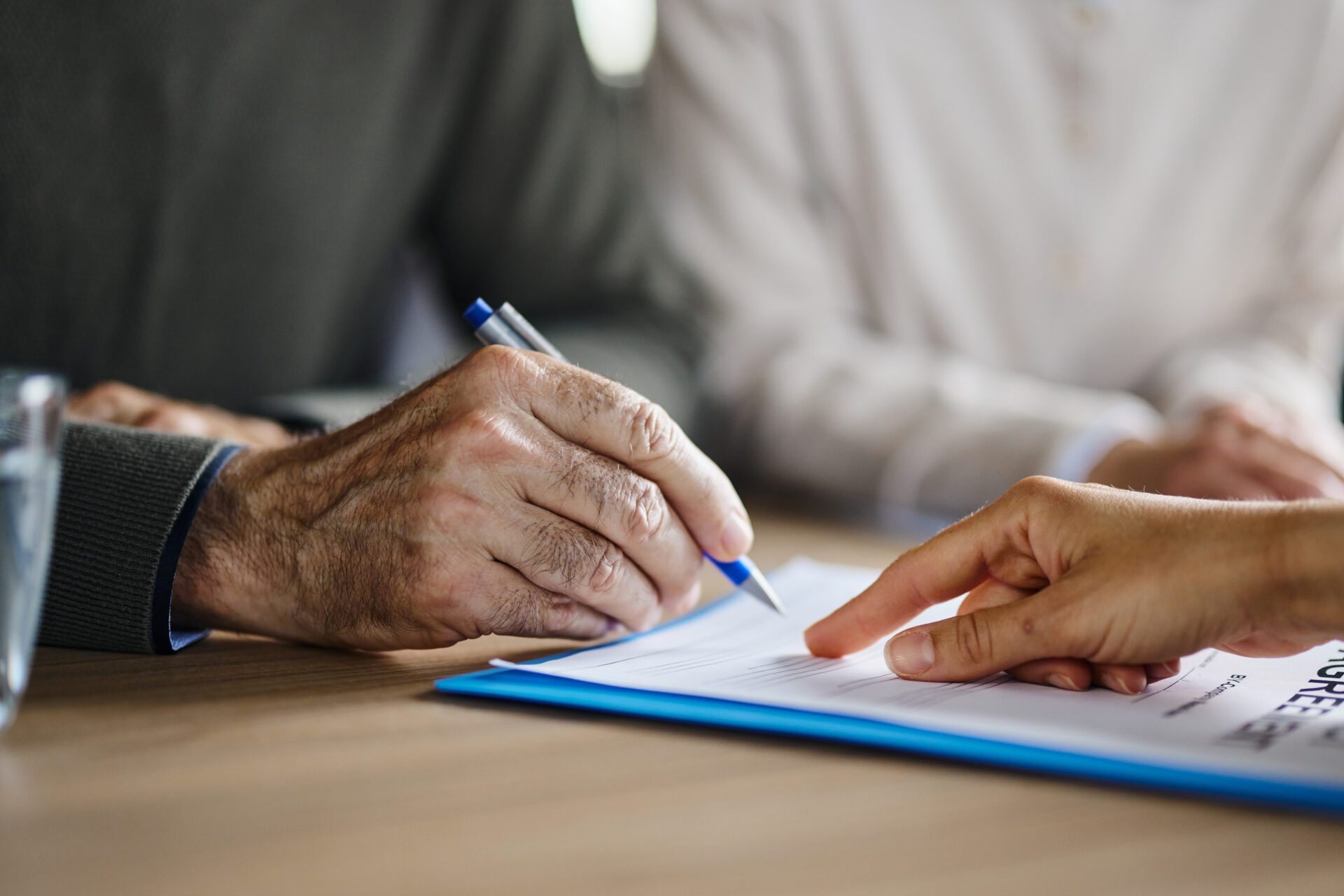 Image of unrecognizable person signing a contract.