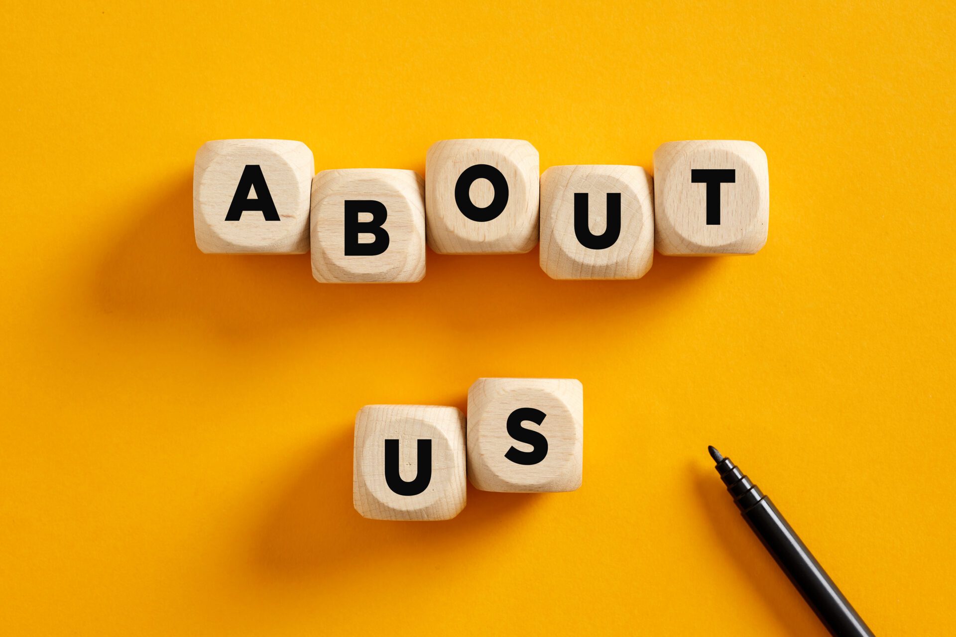 Image of wooden cubes spelling out the words About Us