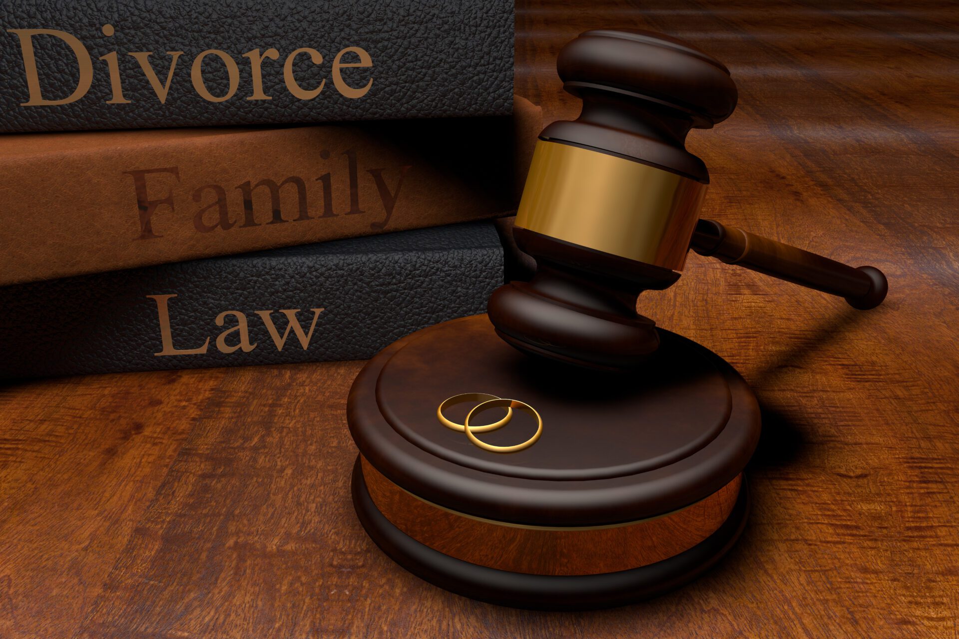 Image of a stack of three textbooks with the words "divorce," "family" and "law" written in gold print. 